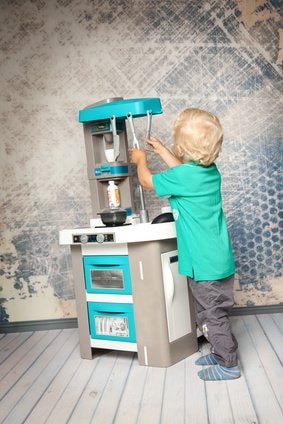 Junge spielt mit Tefal Kinderküche